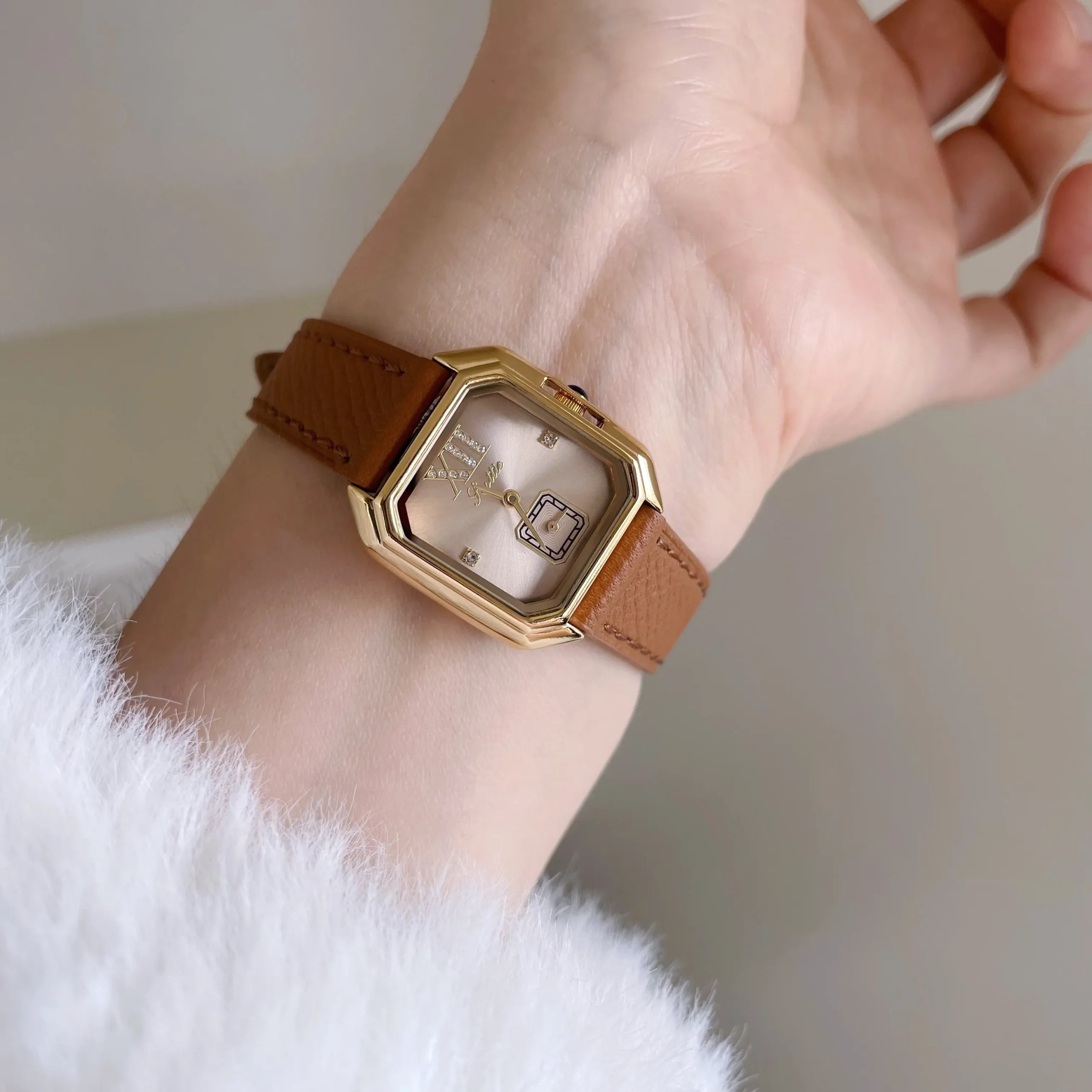 Wrist model wearing vintage ladies watch with gold dial and brown strap