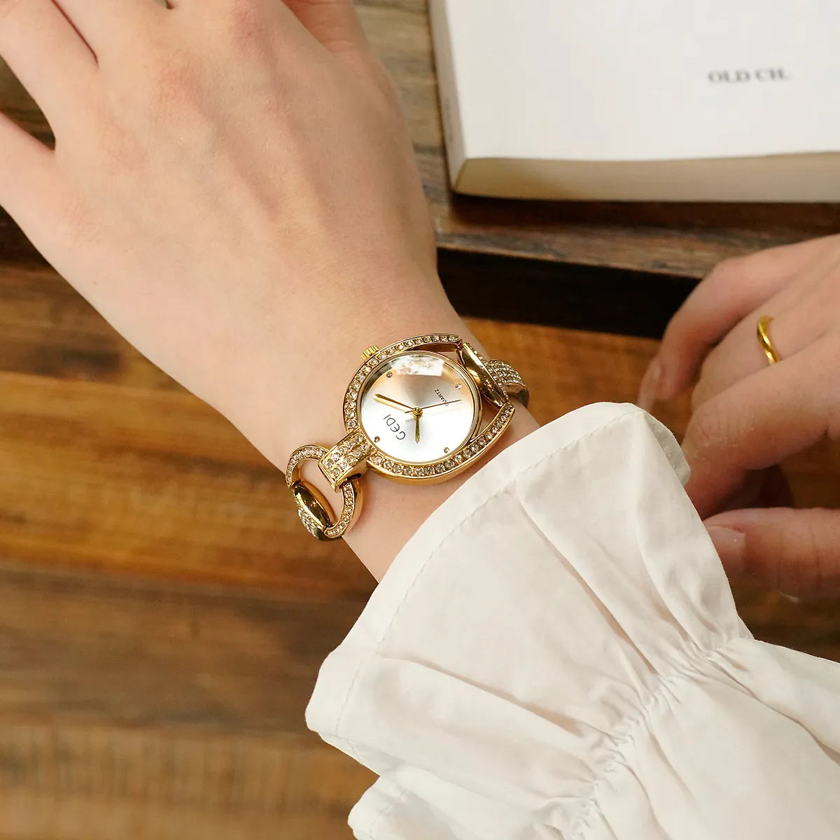 Gold vintage bracelet watch for women shown on wrist with elegant outfit