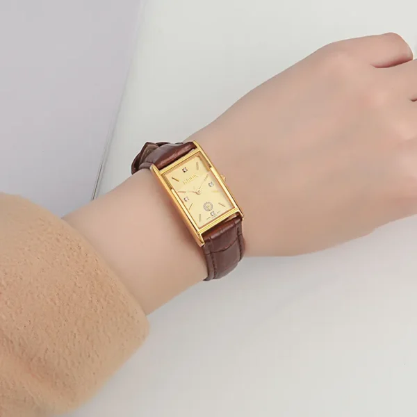Vintage leather women’s watch with brown strap and gold rectangular dial on wrist – WatchTrio