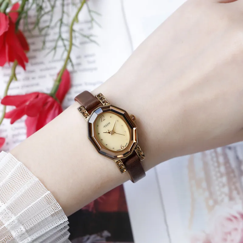 Vintage brown leather strap women’s watch with crystal bezel, worn on wrist