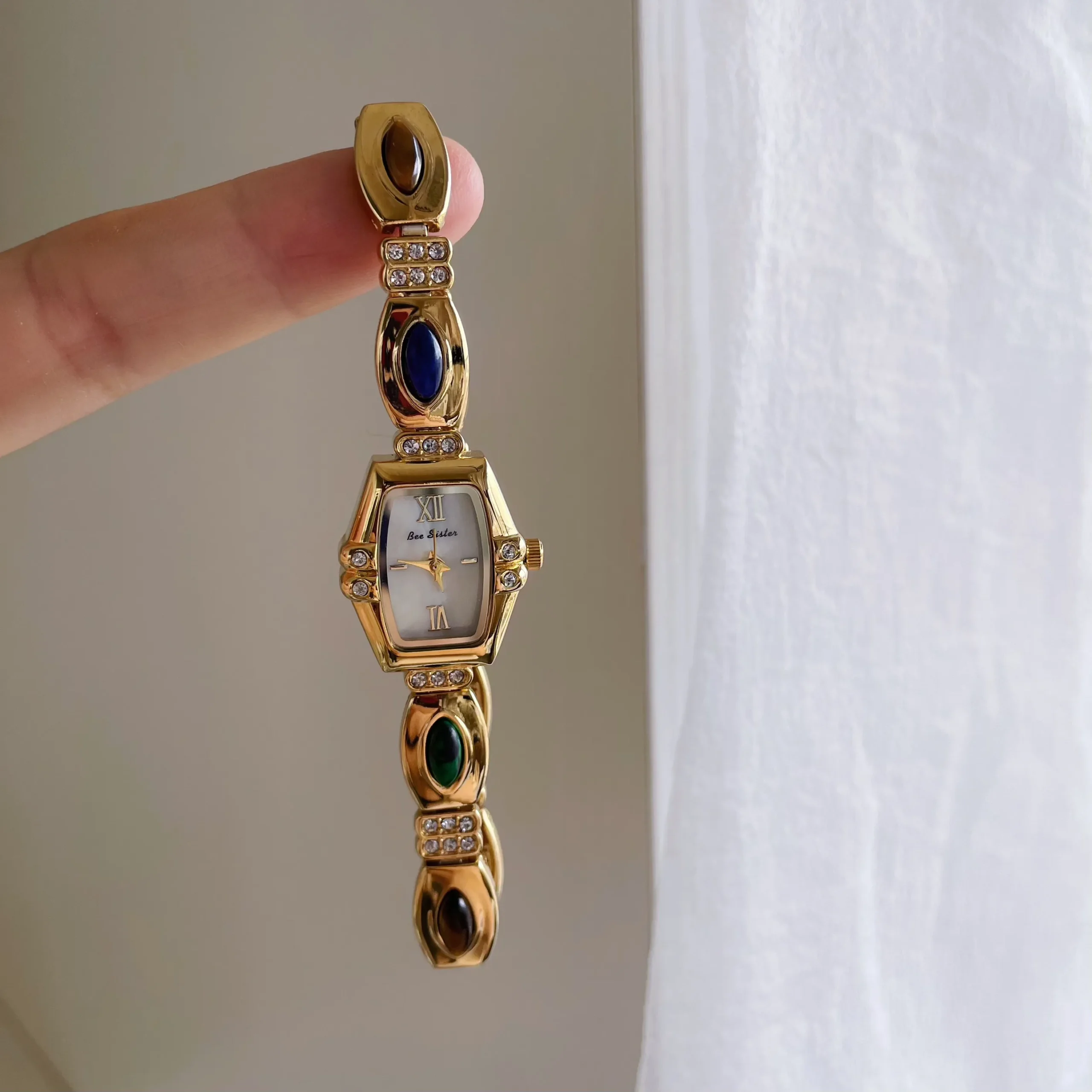 Vintage women’s gold bracelet watch with gemstone accents and small barrel-shaped dial – WatchTrio