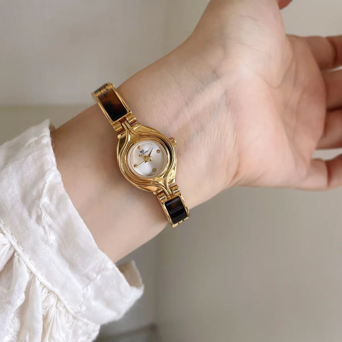 Vintage gold oval women’s watch with white dial on wrist – WatchTrio