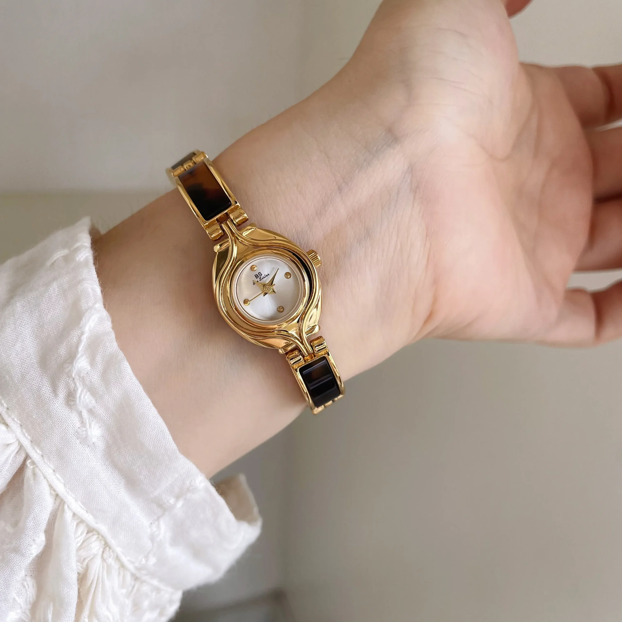 Vintage gold oval women’s watch with white dial on wrist – WatchTrio