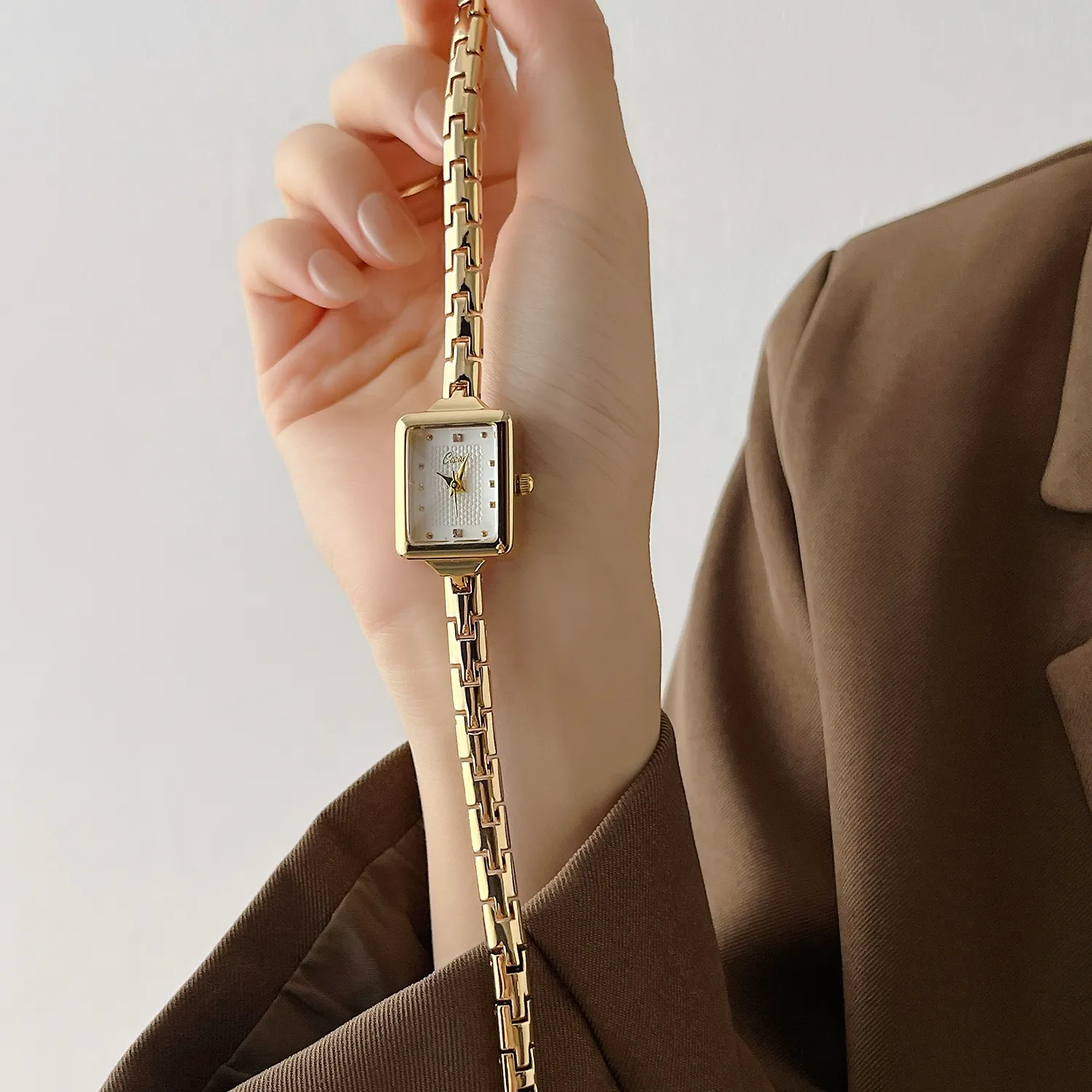 Vintage gold rectangular women’s watch on hand with white dial – WatchTrio