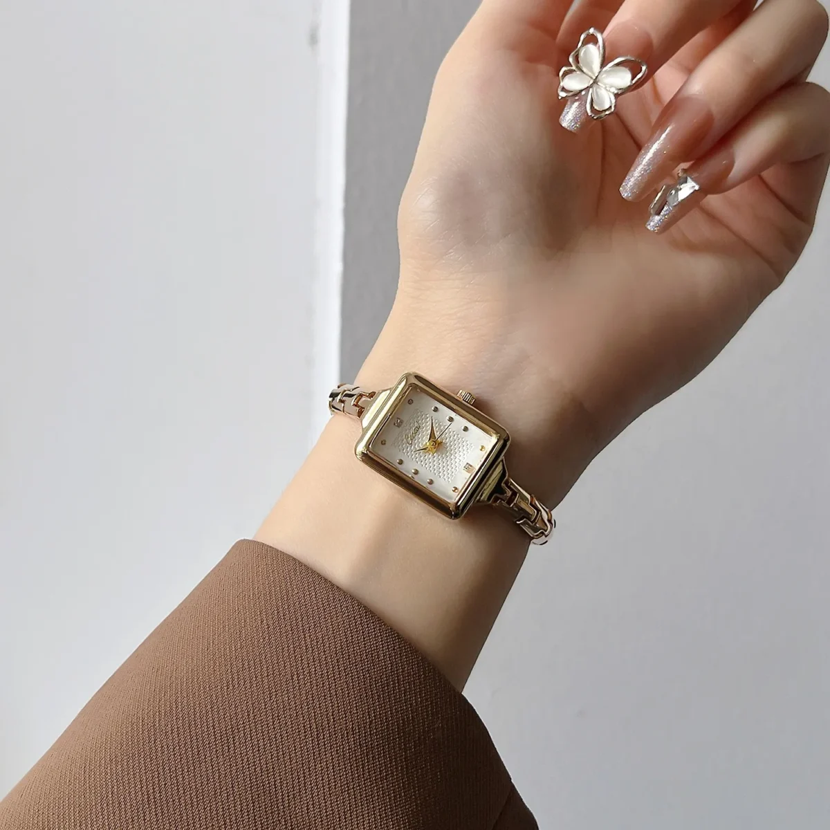 Vintage gold rectangular bracelet women’s watch worn on wrist with white dial