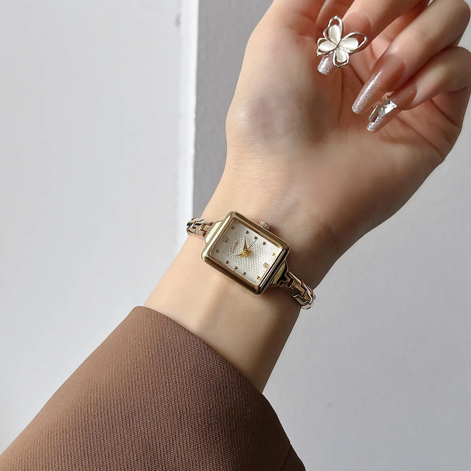 Vintage gold rectangular bracelet women’s watch worn on wrist with white dial