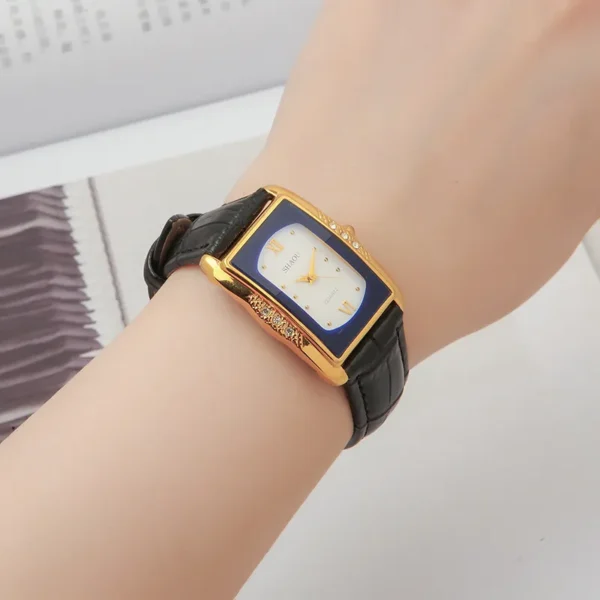 Vintage rectangular women’s watch with black leather strap and white dial, crystal bezel