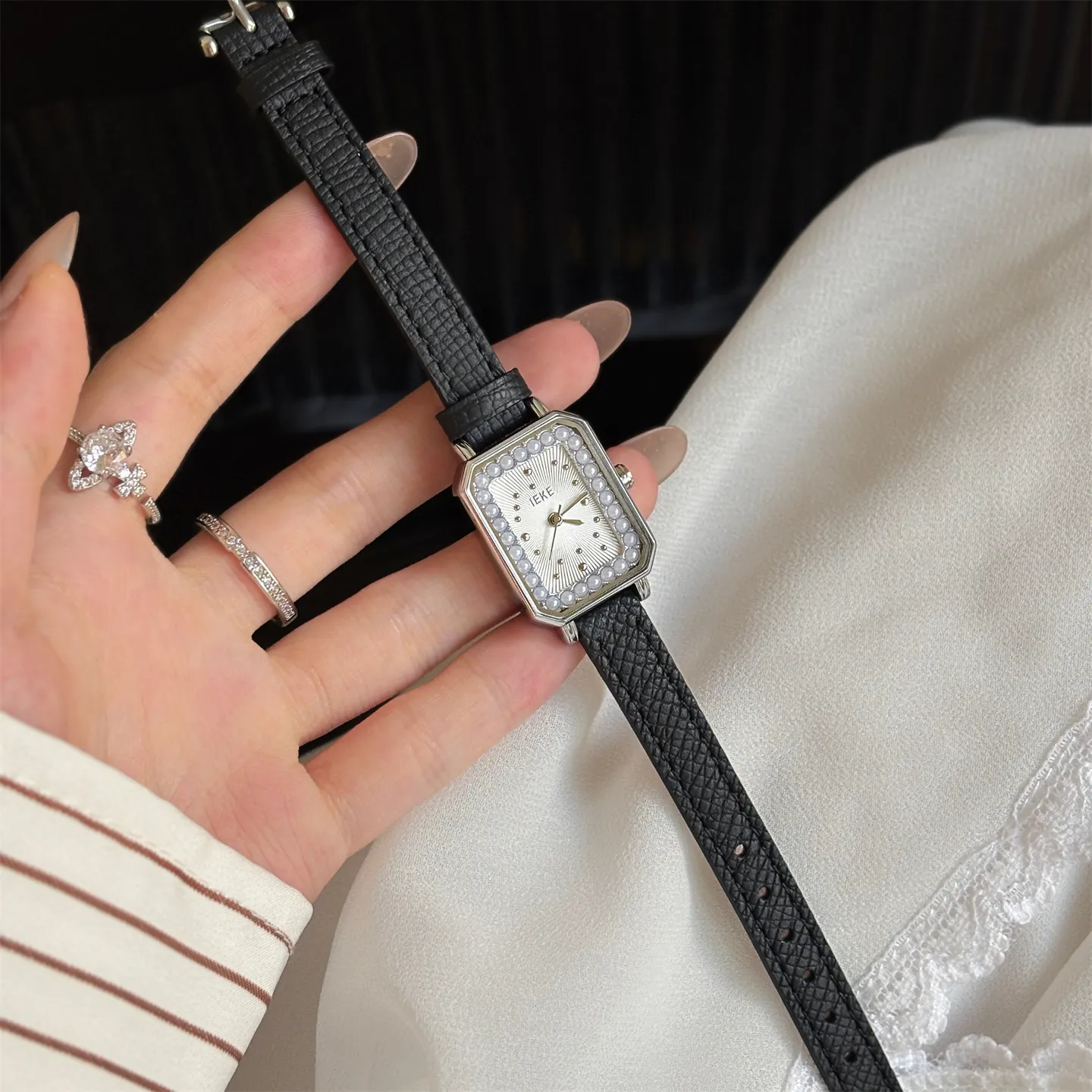 Silver square womens watch with pearl border and black leather band