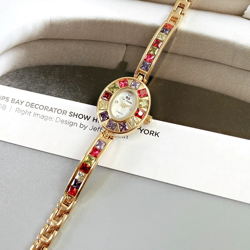 Vintage Rainbow Gemstone Gold Women’s Bracelet Watch – worn on wrist with rose accents – WatchTrio