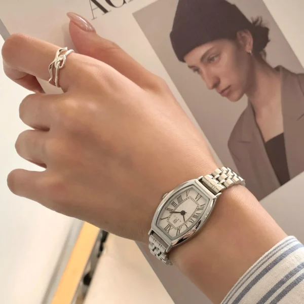 Vintage silver women’s watch on wrist with barrel (tonneau) case and Roman numerals