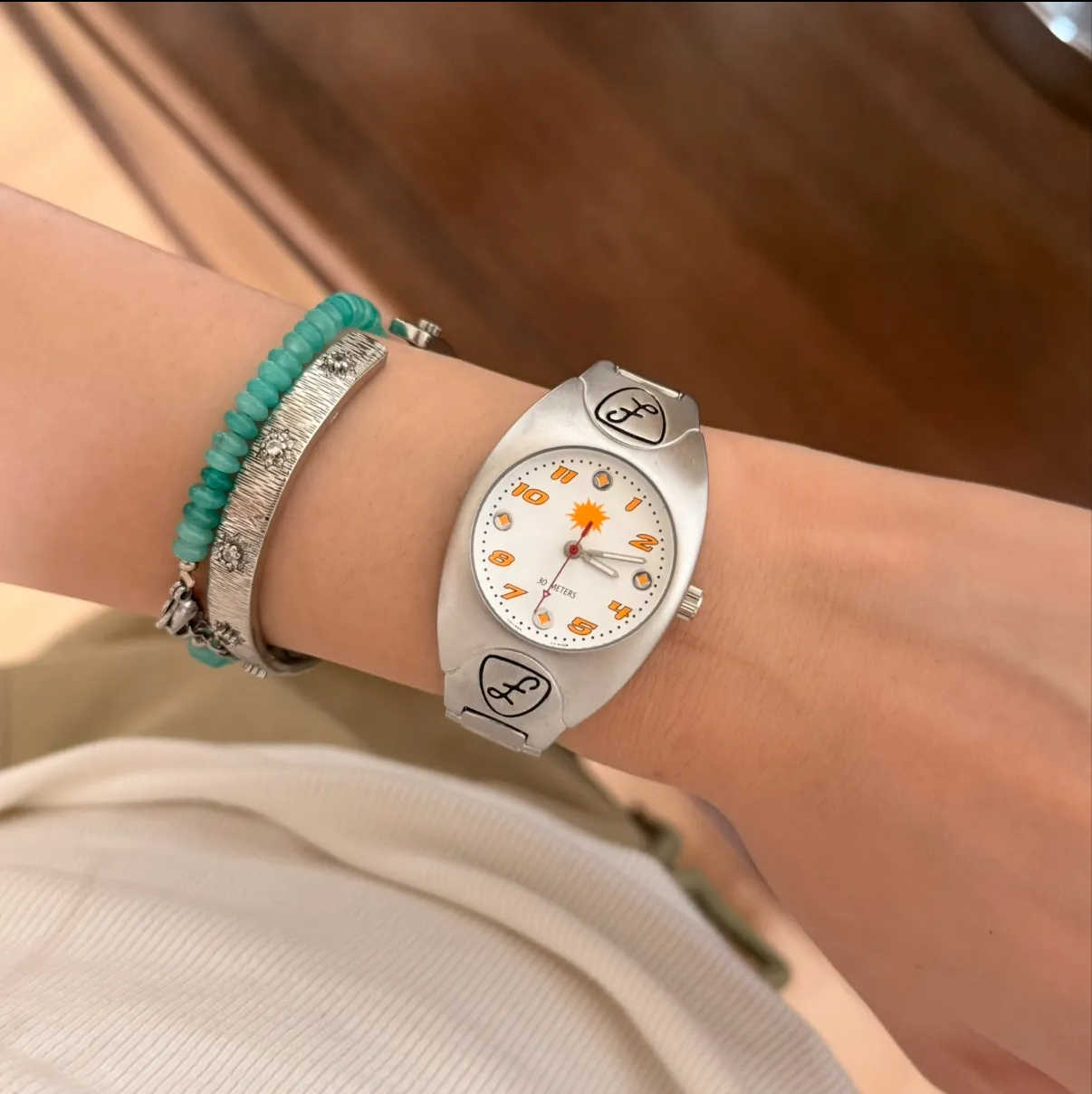 Vintage silver women’s quartz watch with white dial and sunburst spark design