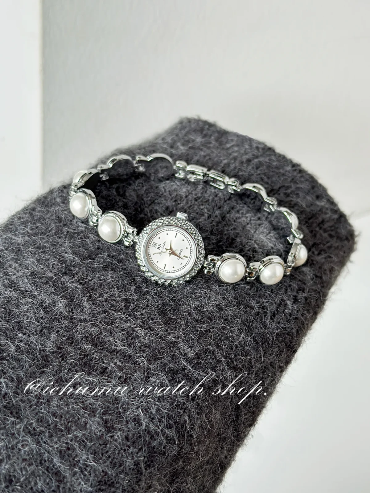 Flatlay of vintage silver women’s watch with pearl bracelet design – WatchTrio