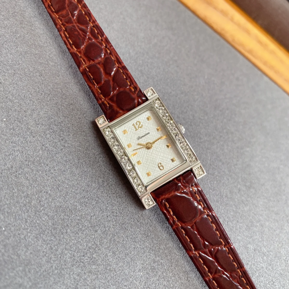 Flat lay of vintage women’s leather rectangle diamond watch with red strap – WatchTrio