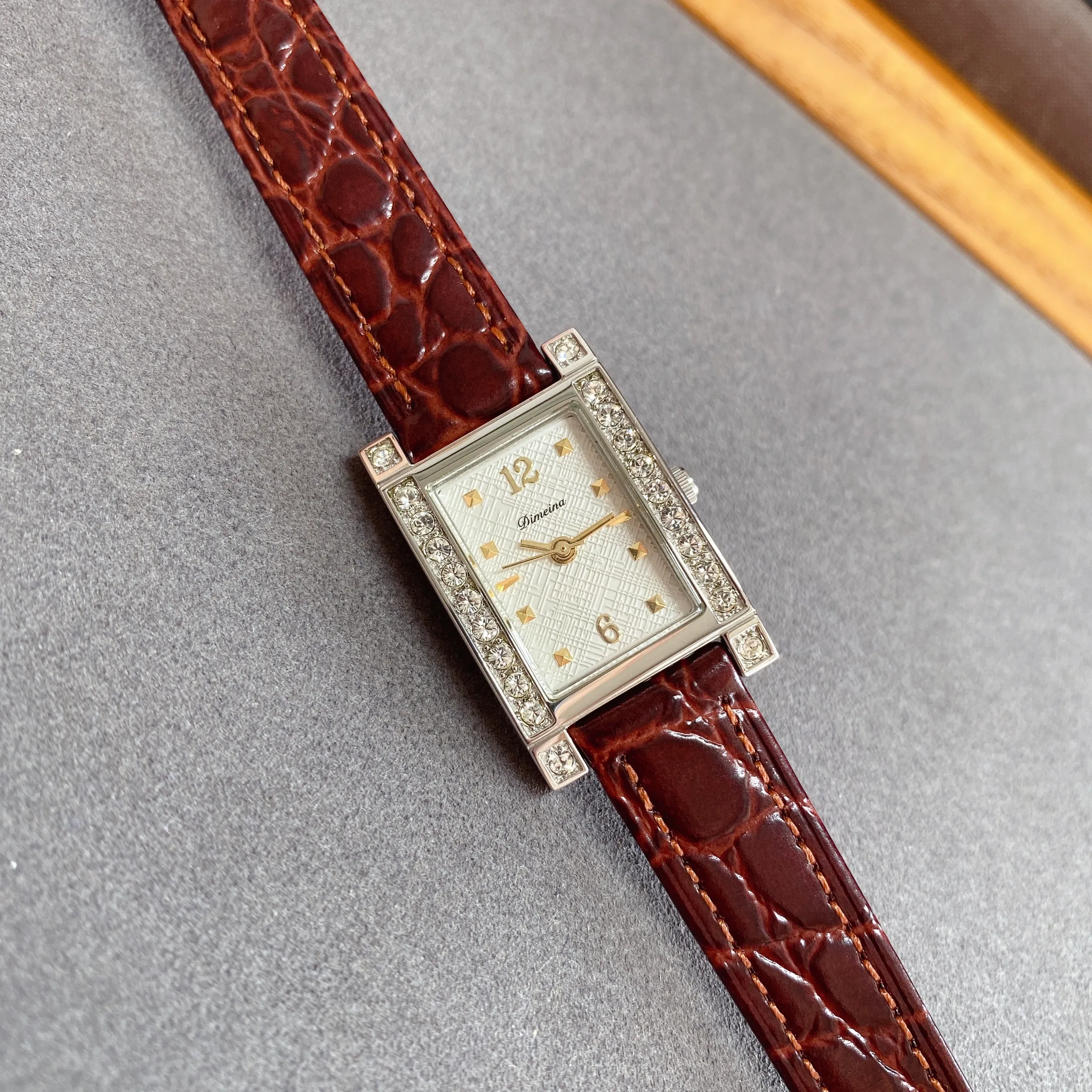 Flat lay of vintage women’s leather rectangle diamond watch with red strap – WatchTrio