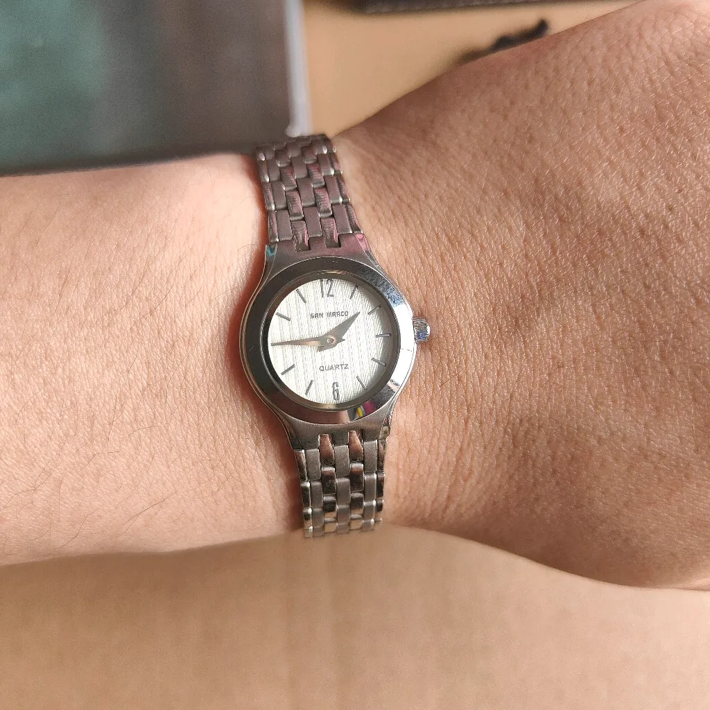 Vintage women’s silver quartz watch on wrist with stainless steel bracelet