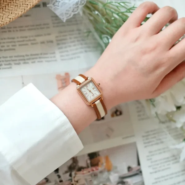 Flatlay of women’s vintage square quartz watch with leather strap